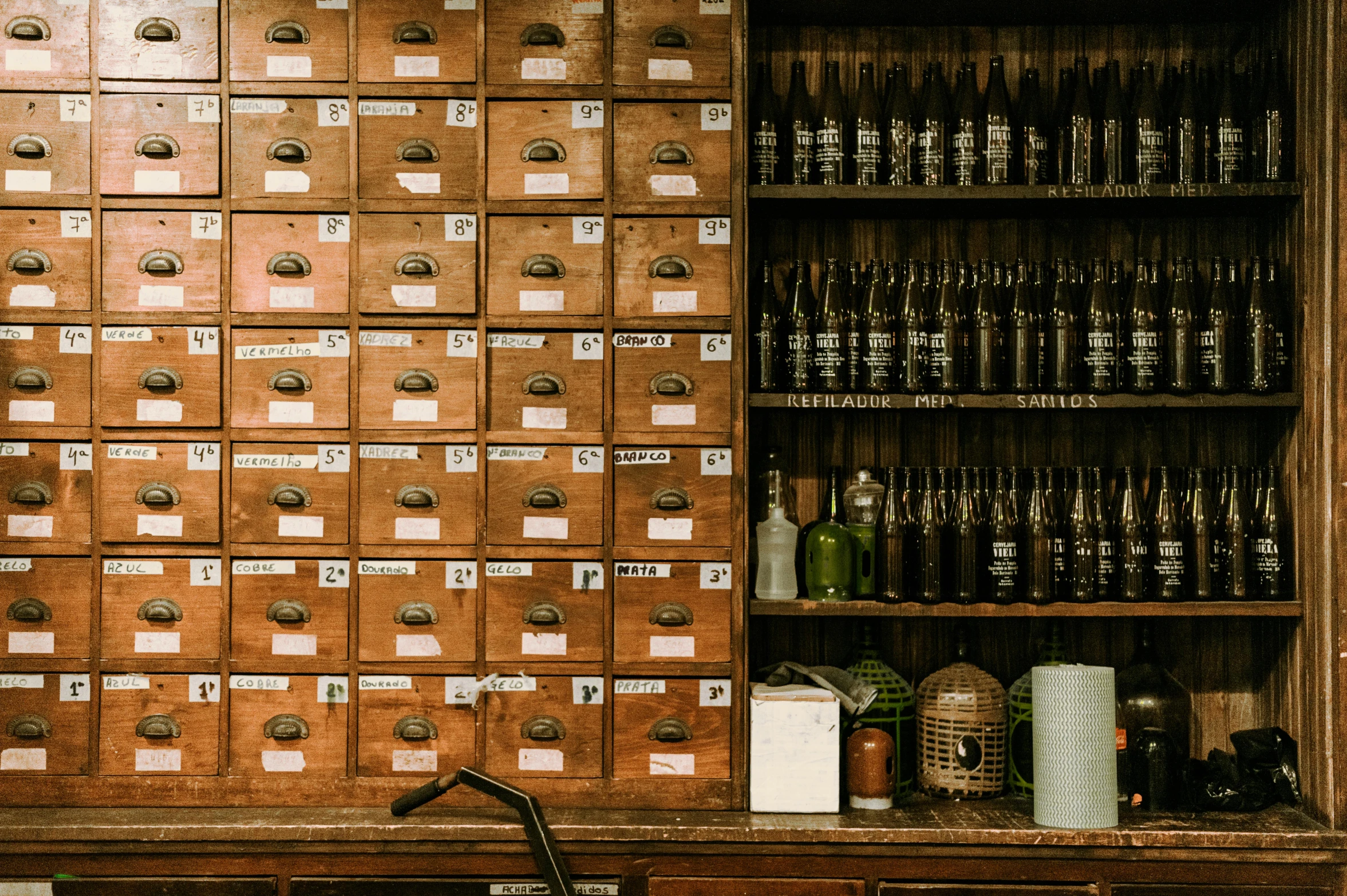 a wooden cupboard with several beer bottles and cans inside of it