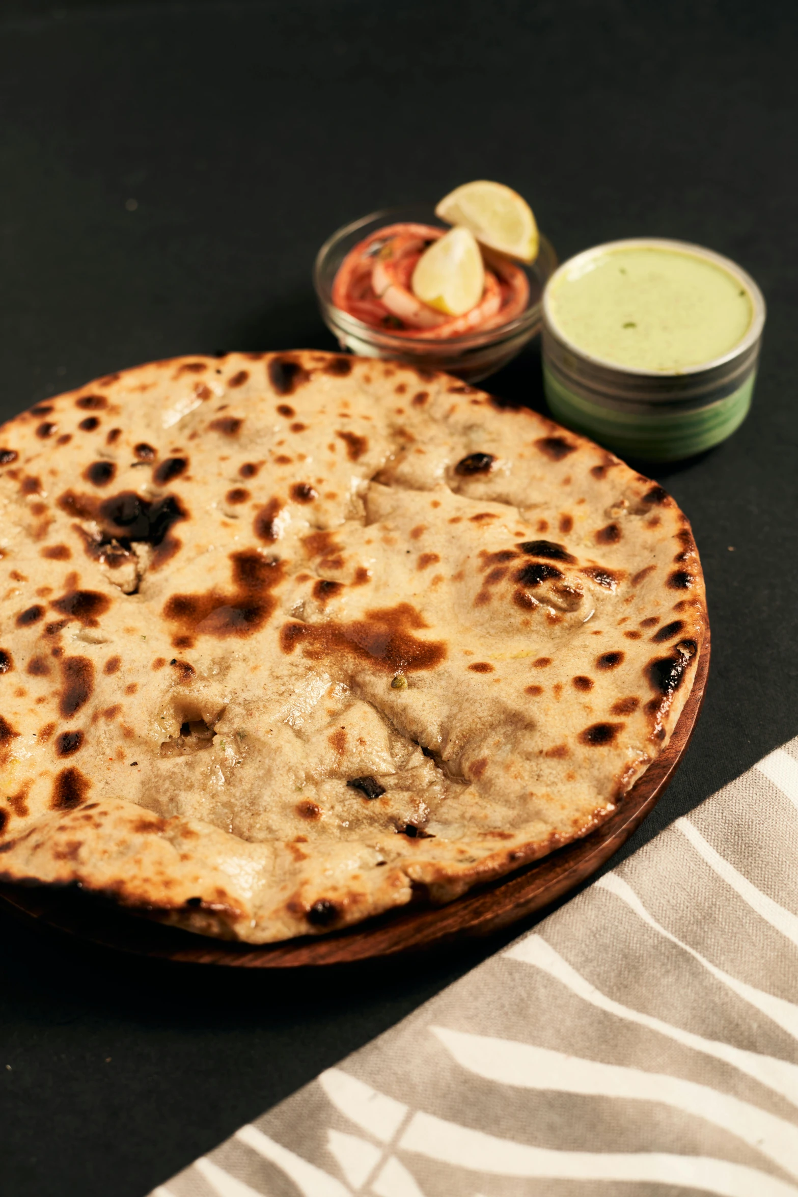 a flatbread on a plate with two condiments