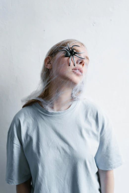 a woman is wearing plastic hair and she's covered in spider web