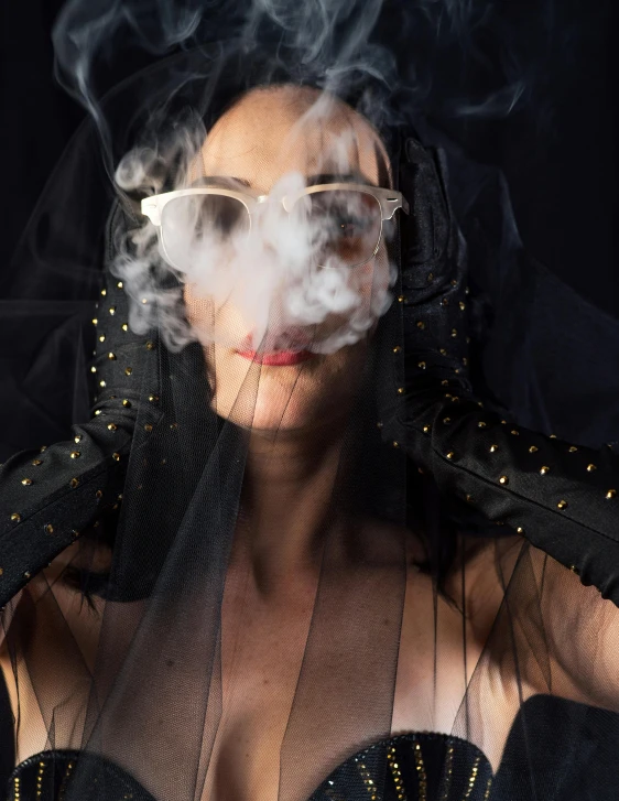 the woman is smoking soing with her face obscured by steam