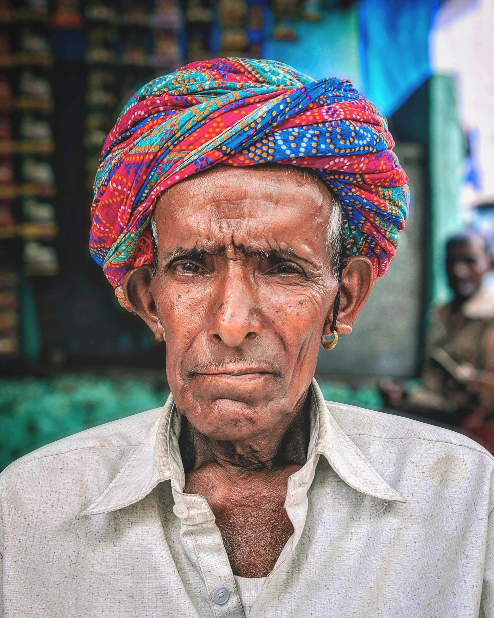 an old man wearing colorful head coverings in front of a store