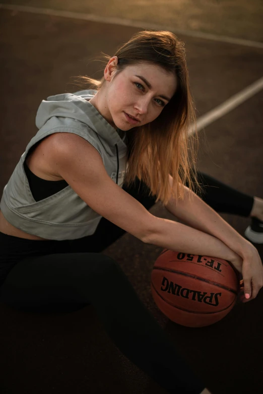 a girl is sitting with her feet on a basketball