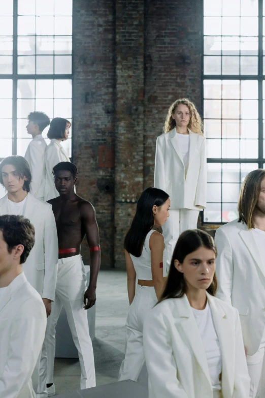 models walk down a runway with white coats and black pants