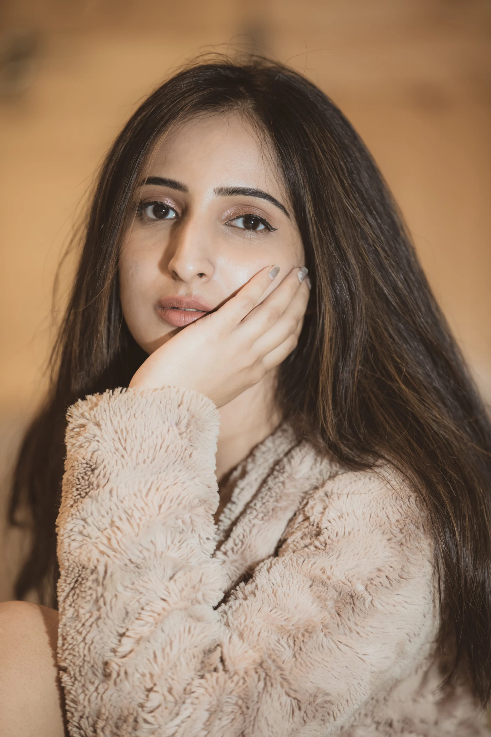 woman with long hair posing with her hand over the face