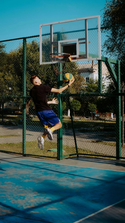 man with black shirt jumping in the air after playing basketball