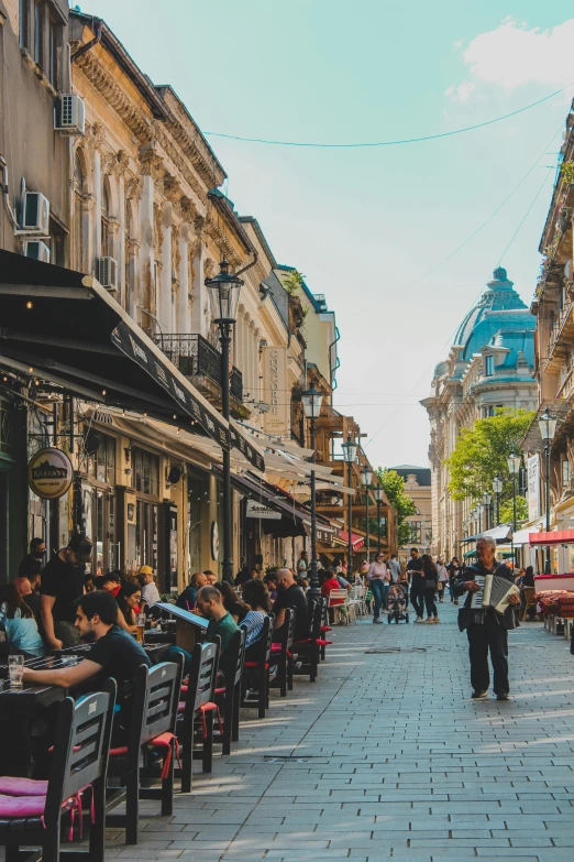 many people sitting in chairs on a city street