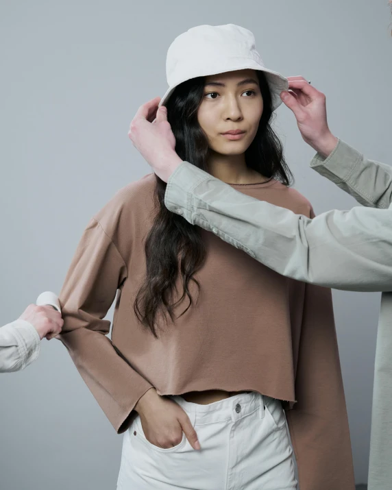 the girl is trying on the hat and she also seems unhappy