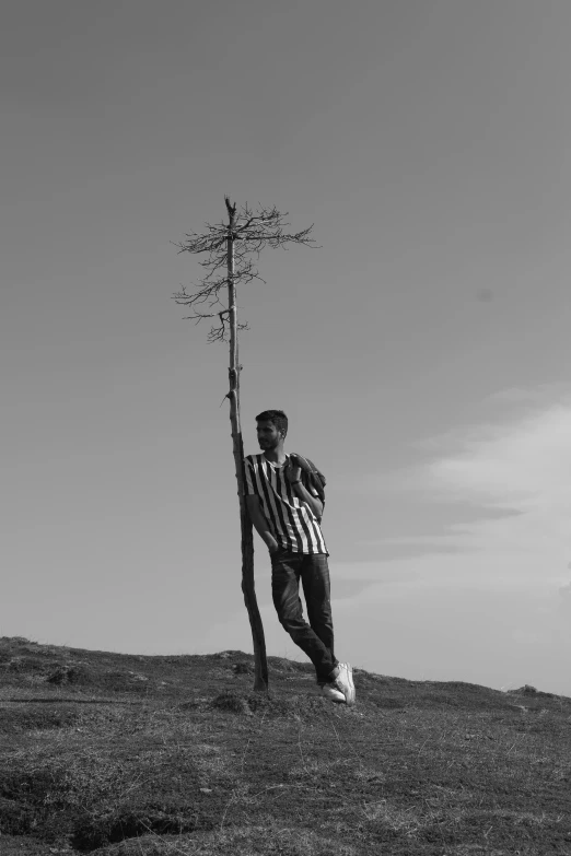 man holding a metal tool next to a tree