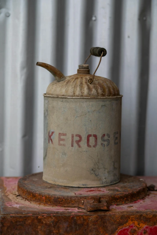 the old metal jar has a small spoon on top of it