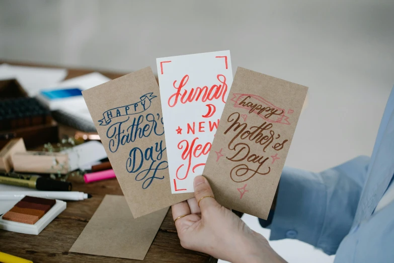 a person holds three cards with words on them