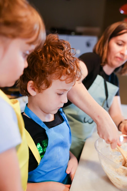 a mother and her children baking soing out of a bowl