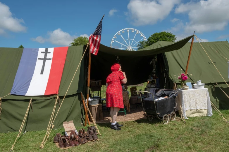 a man stands near a tent in the grass