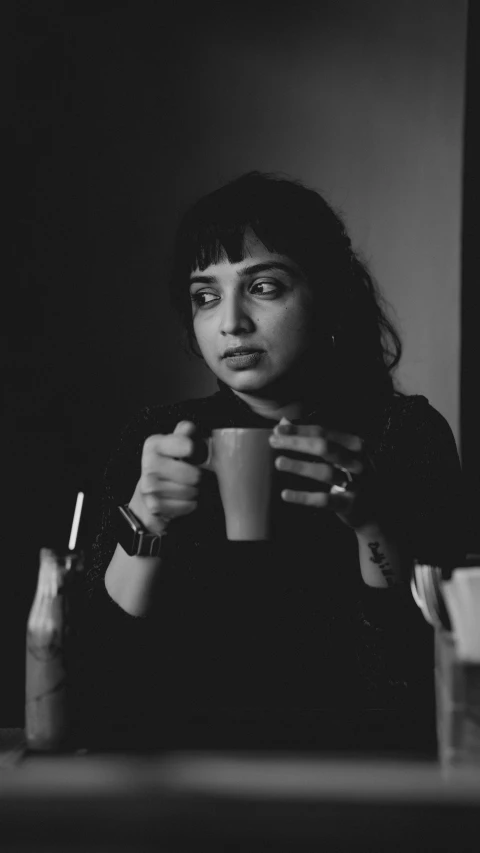 a woman in black holding a cup