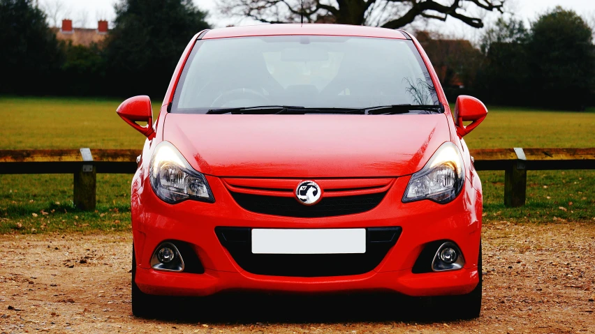 a small red car parked in a parking lot