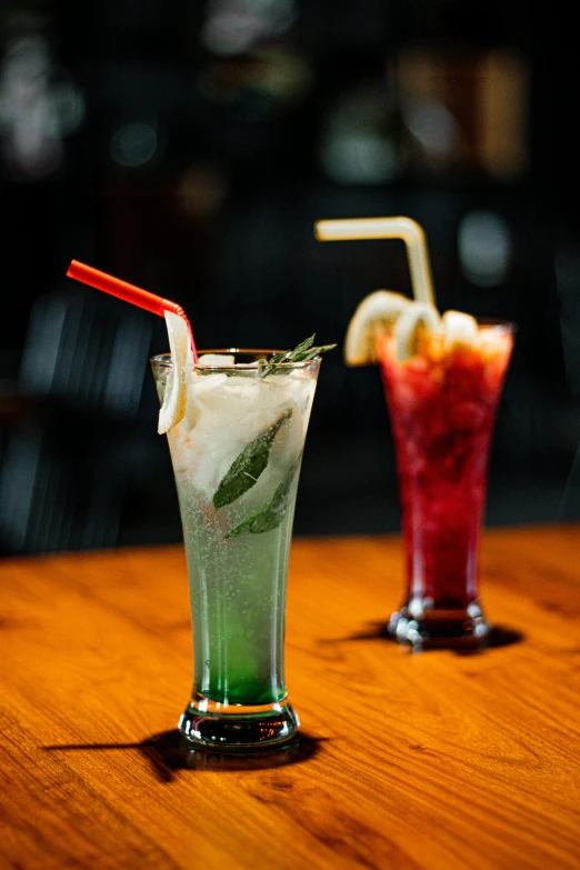 two glasses filled with green and red drinks