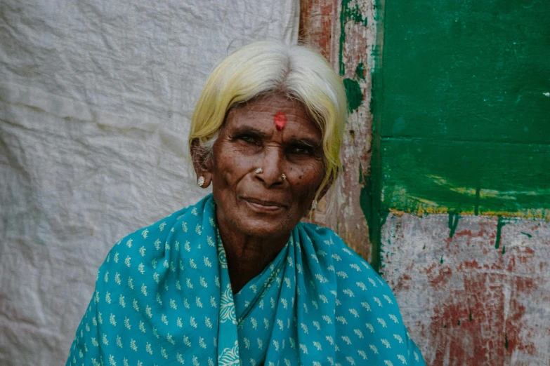 an old indian woman wearing blue is standing