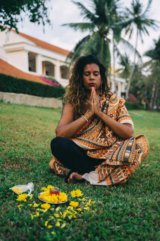 the woman is meditating and praying in the grass