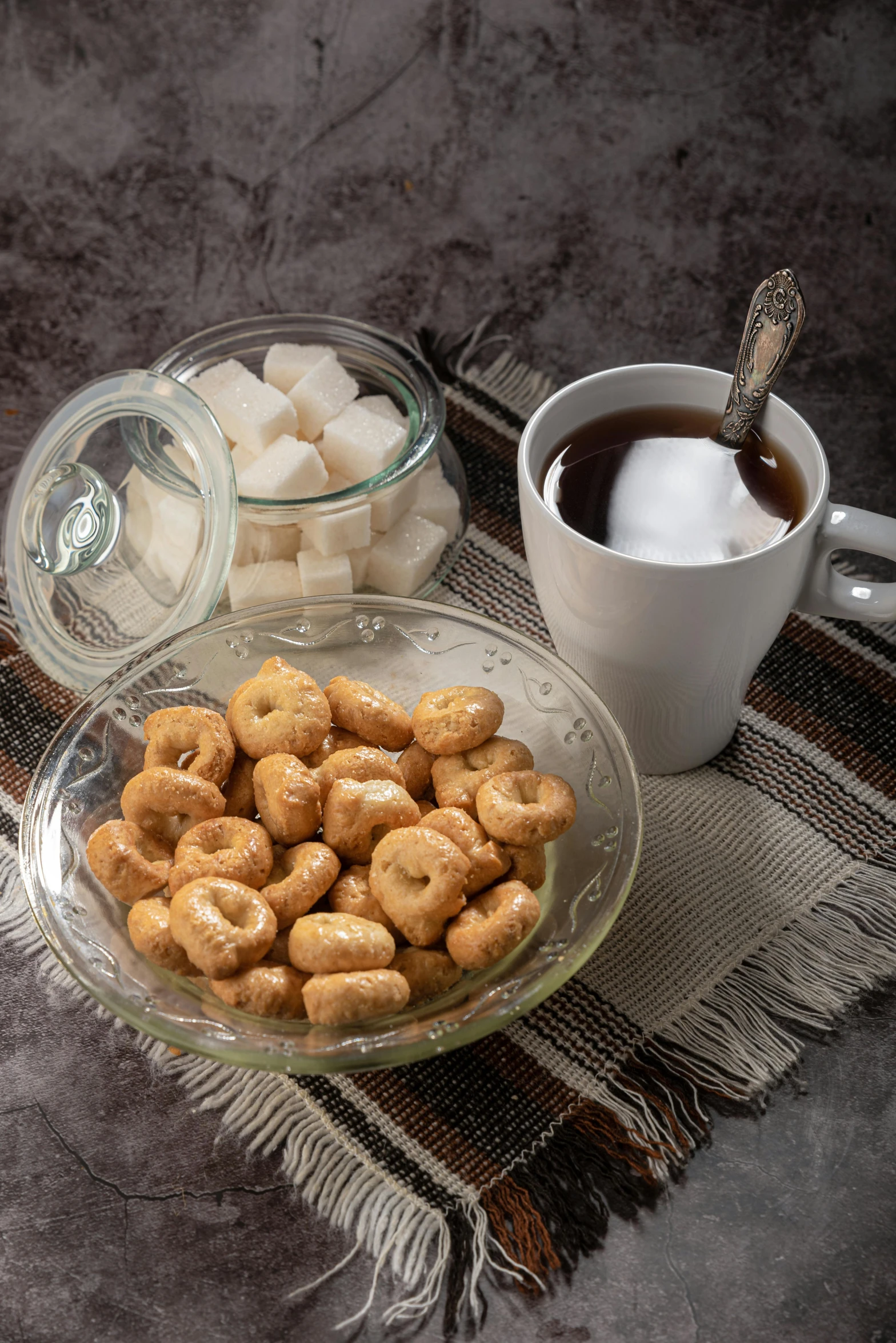 a glass plate with sugar cubes and doughnuts