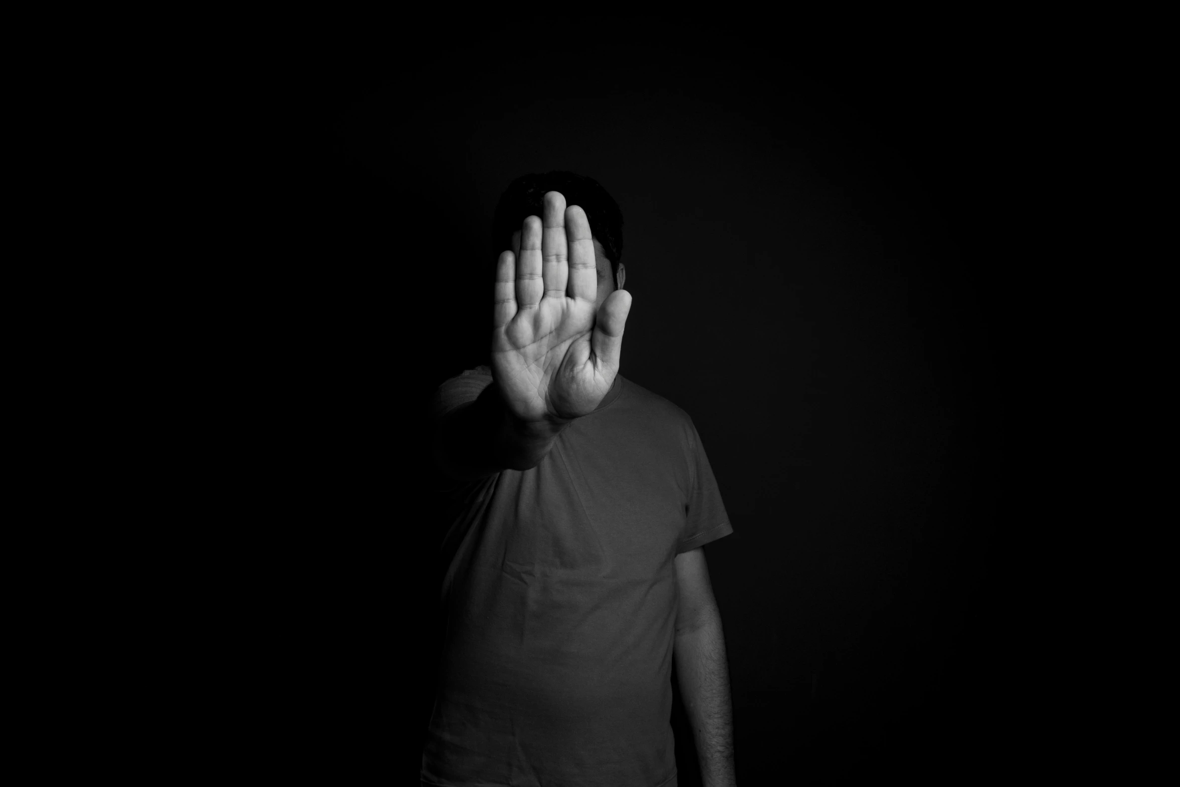 a man standing in the dark with his hands up