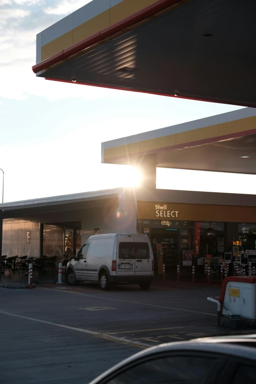 a white truck sitting next to a gas station