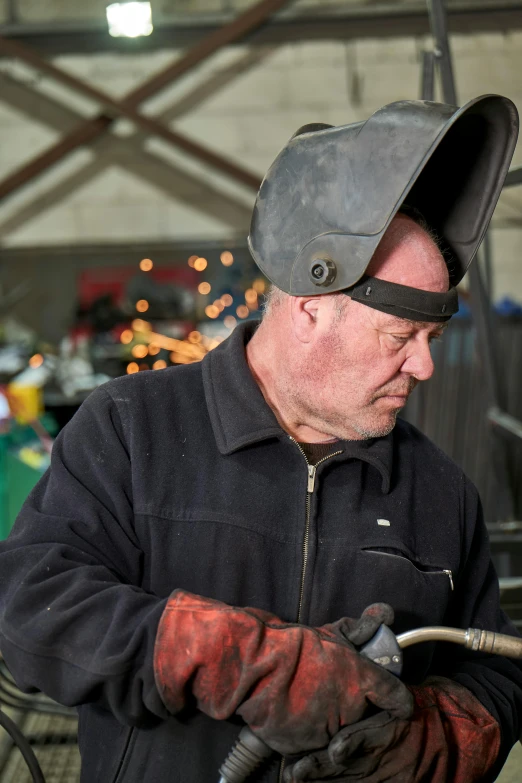 a man working on a truck with his hands on the hose