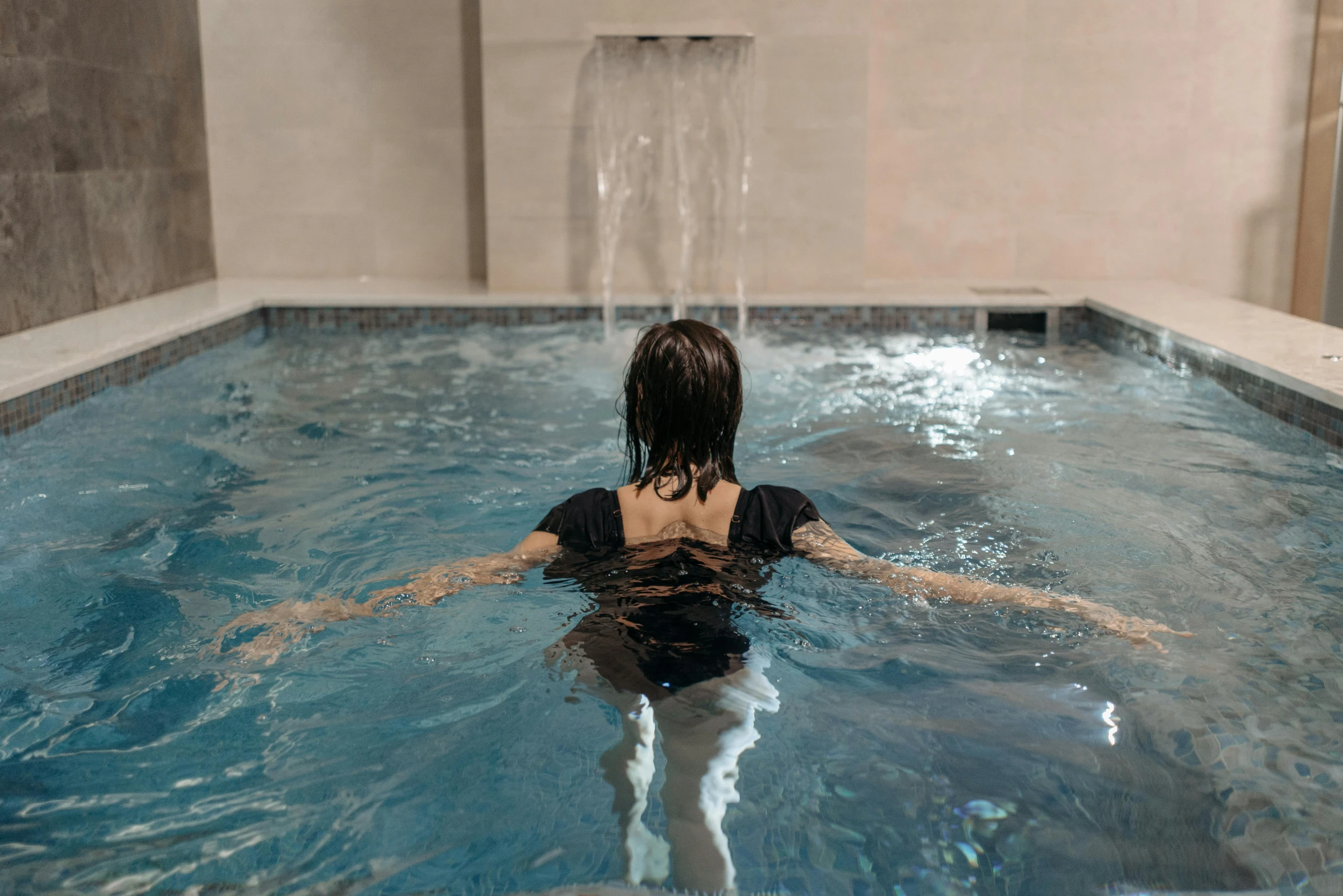 a woman floating in the water in a pool