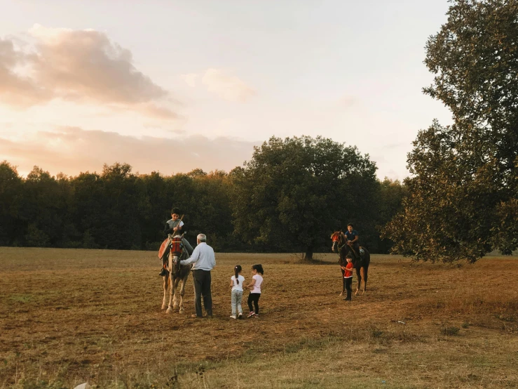 people standing around and watching some very pretty horses