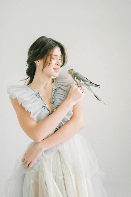 girl wearing a white dress with a bird on her shoulder