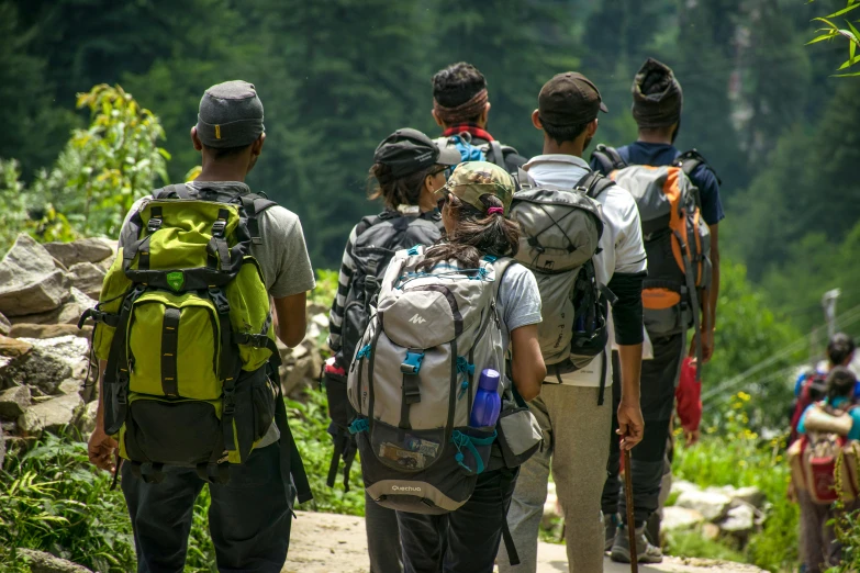 several hikers are heading down a dirt path