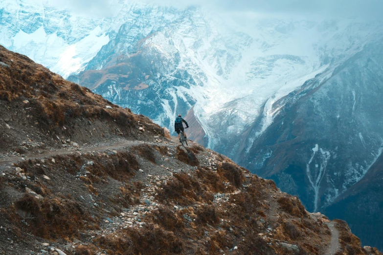 a person climbing up a mountain with snow on top of it