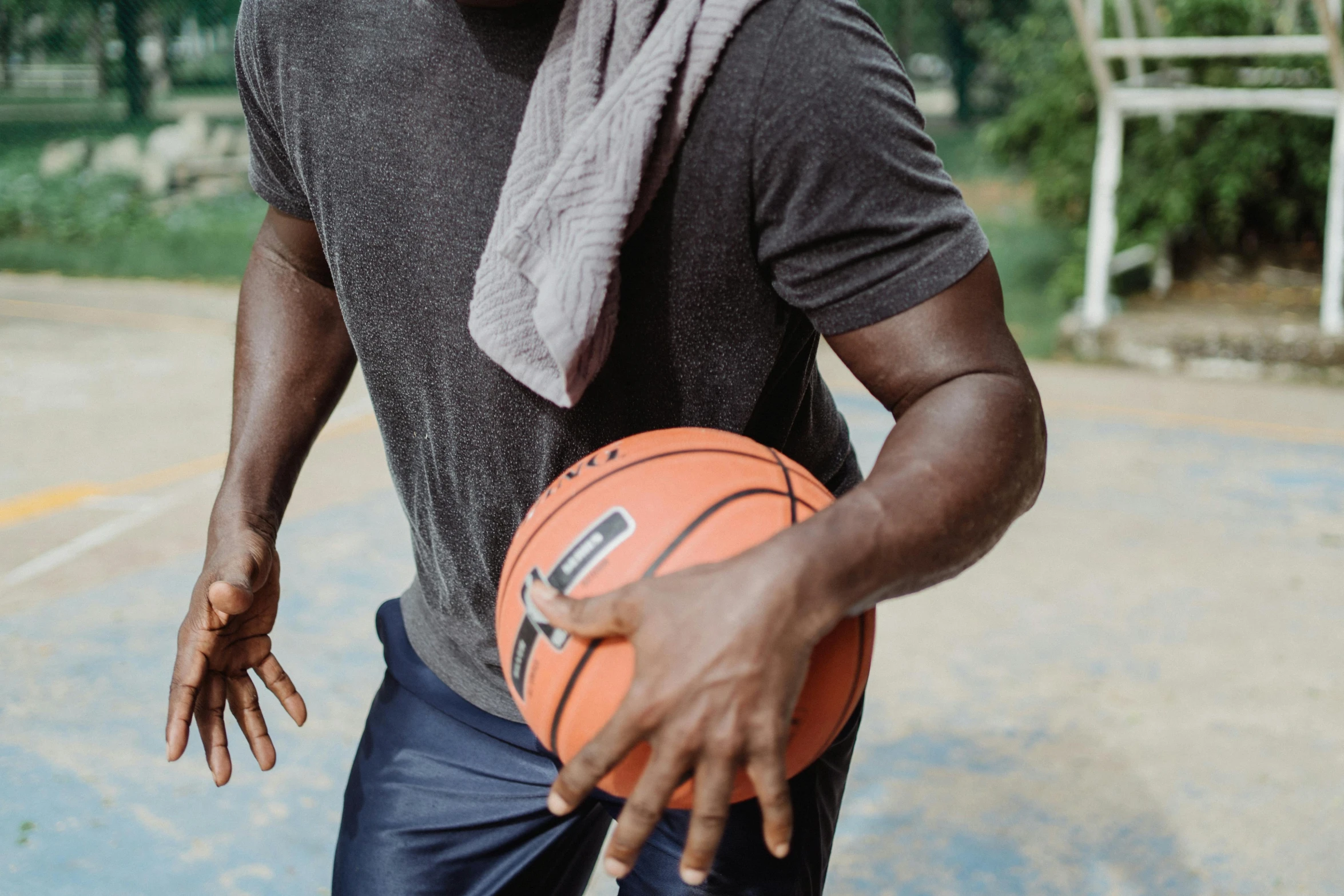 man holding an orange basketball on a road