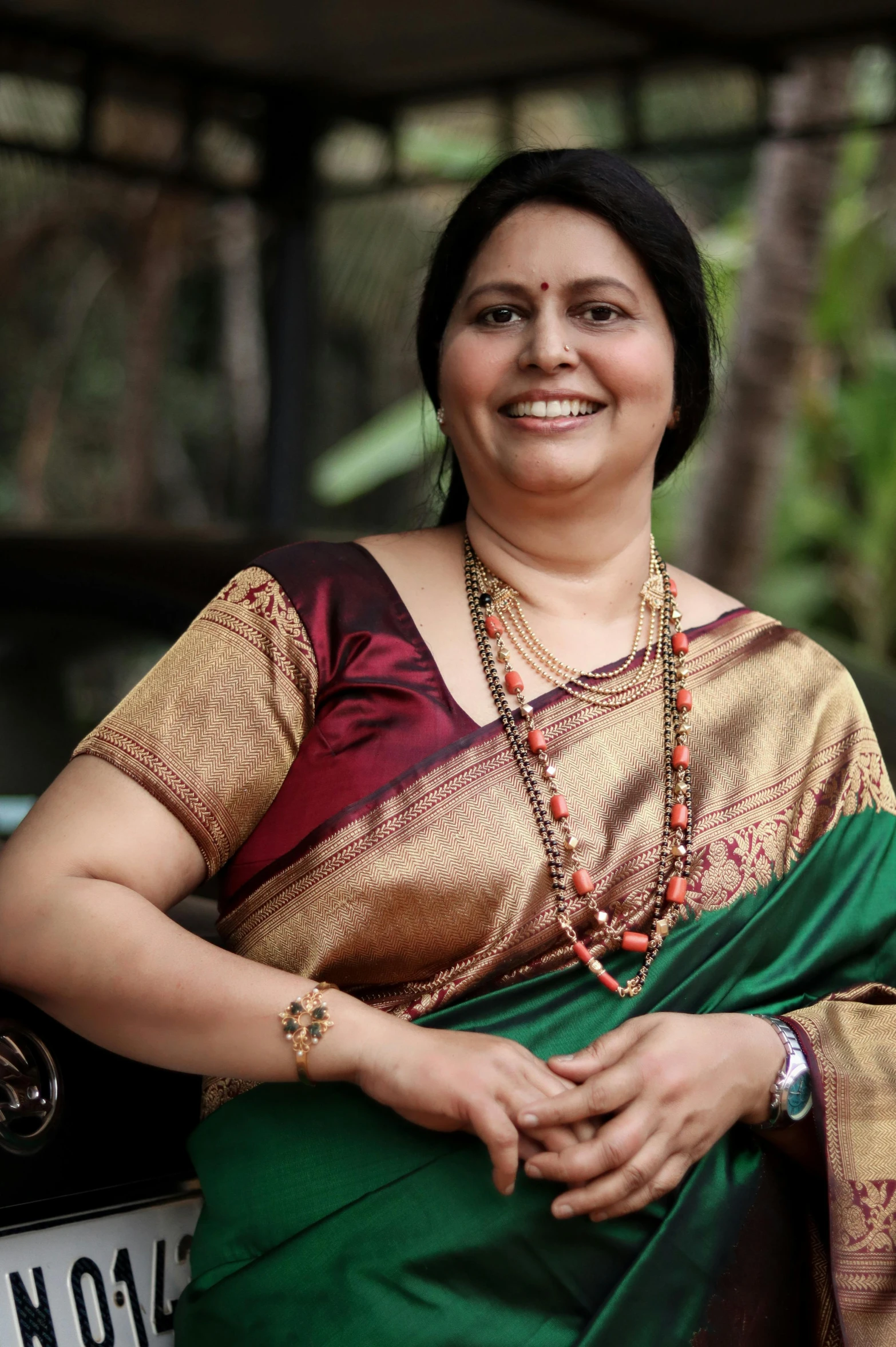 woman smiling at the camera with her saree and necklace