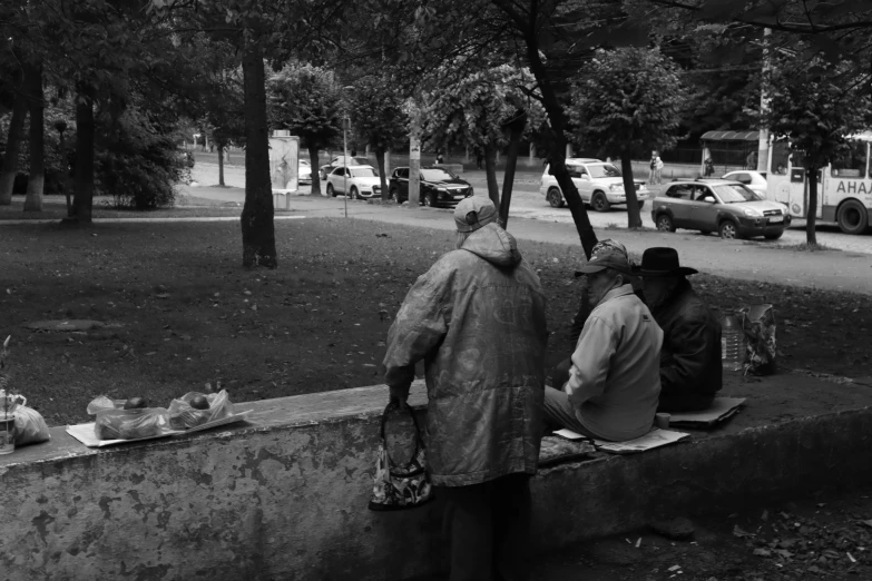 a couple of people sitting on top of a cement wall