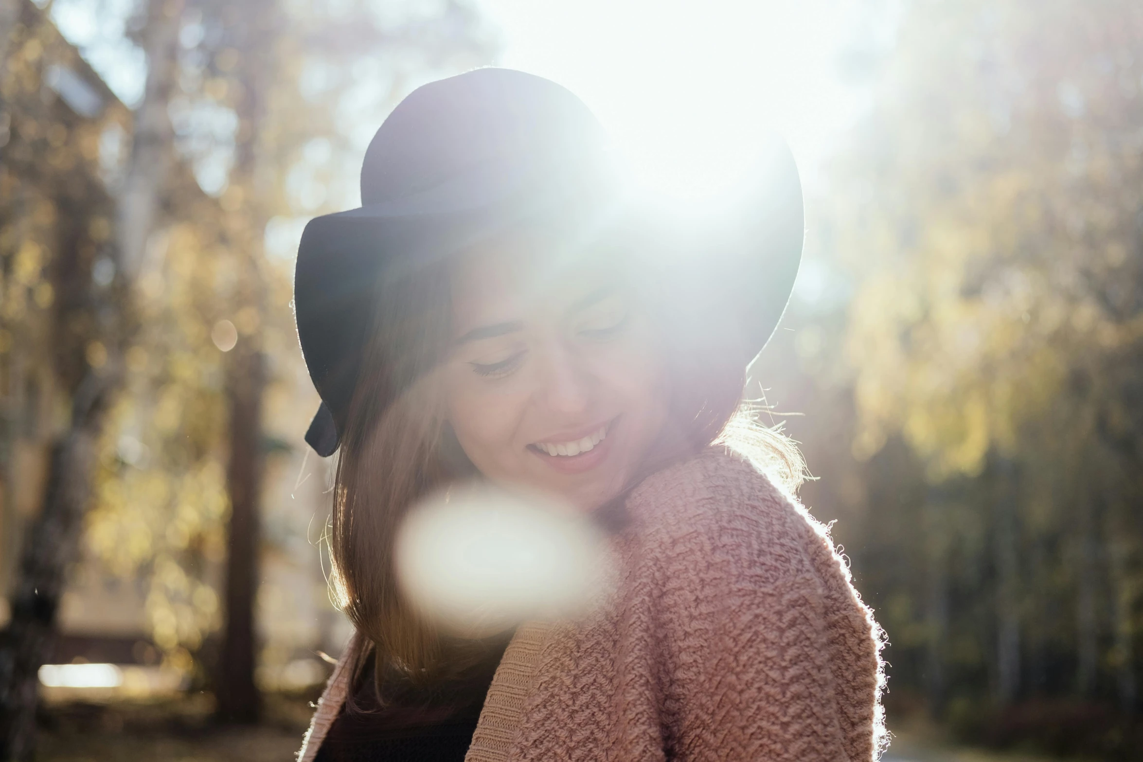 a smiling woman standing outside in the park