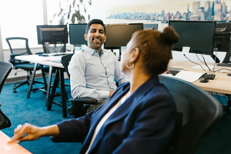 a woman working at an office talking to a man