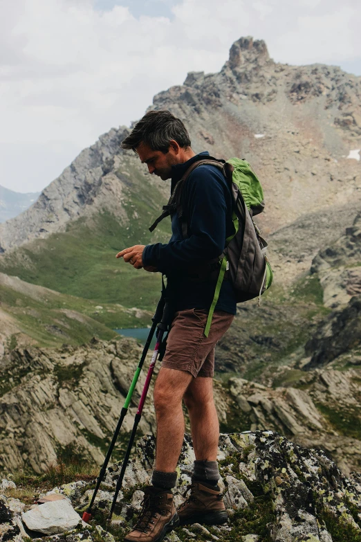 a man hiking up a mountain holding hiking gear