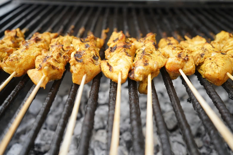 several skewered food items being cooked on a grill