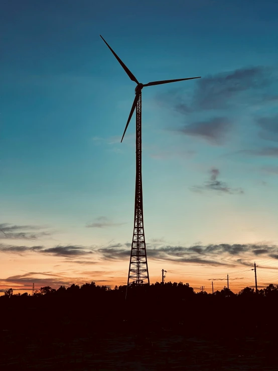 a large windmill that is very tall in the sky