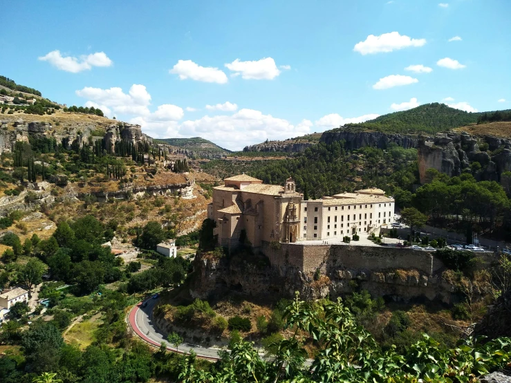 old buildings on the cliff side below a blue sky