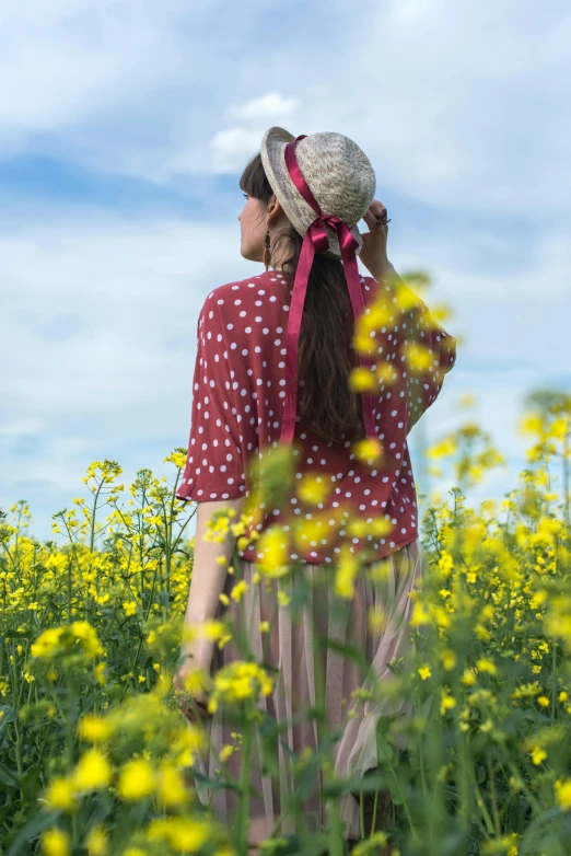 a woman walking in a field of flowers