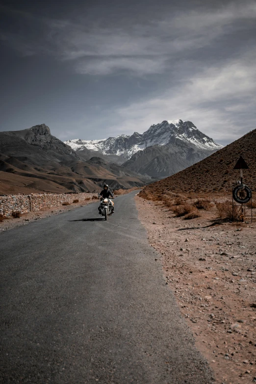 motorcycle rider in the middle of a long deserted road