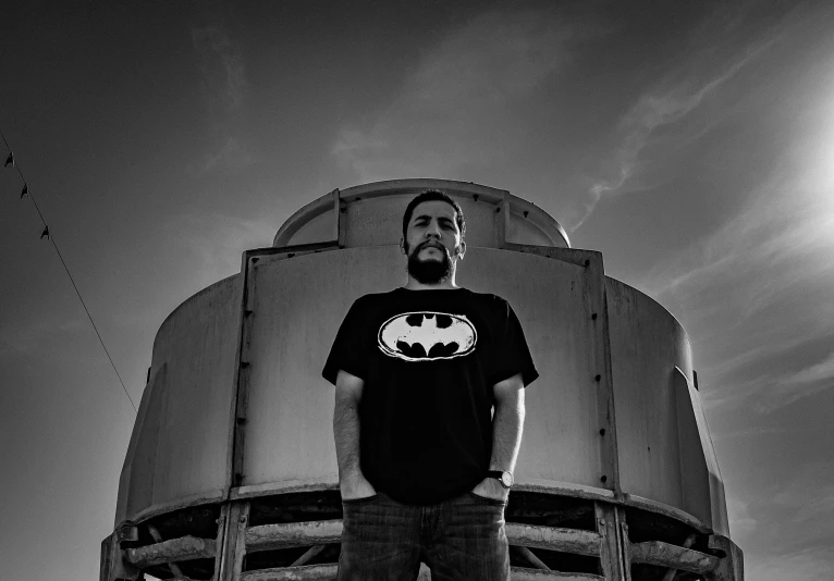 black and white pograph of a man standing outside an airplane hangar