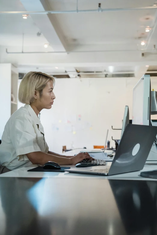 a woman sitting at a desk with a laptop computer