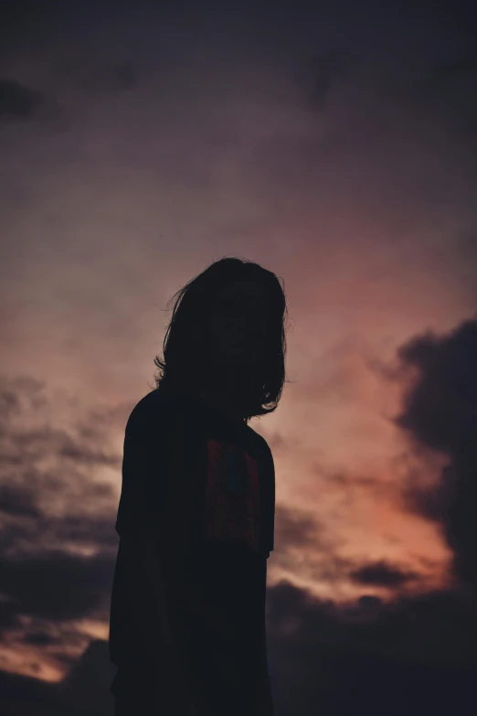 silhouette of man standing on beach at sunset