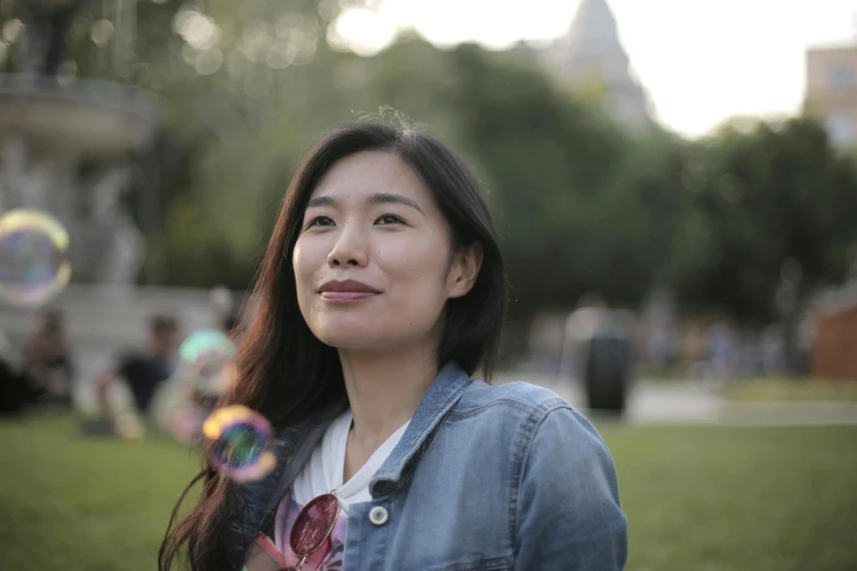 a pretty young lady standing in a park