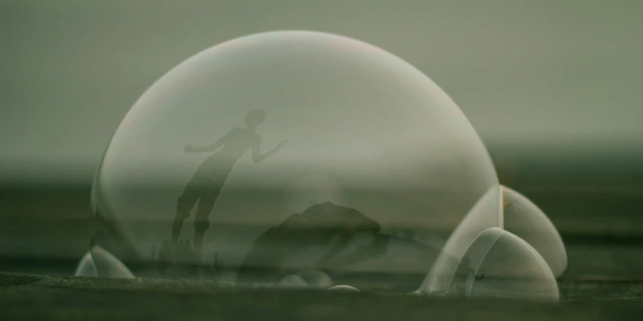 a big glass sphere sitting on top of a sandy beach