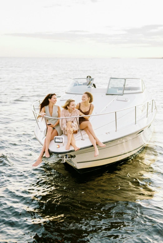 three women hanging out on the bow of a small boat