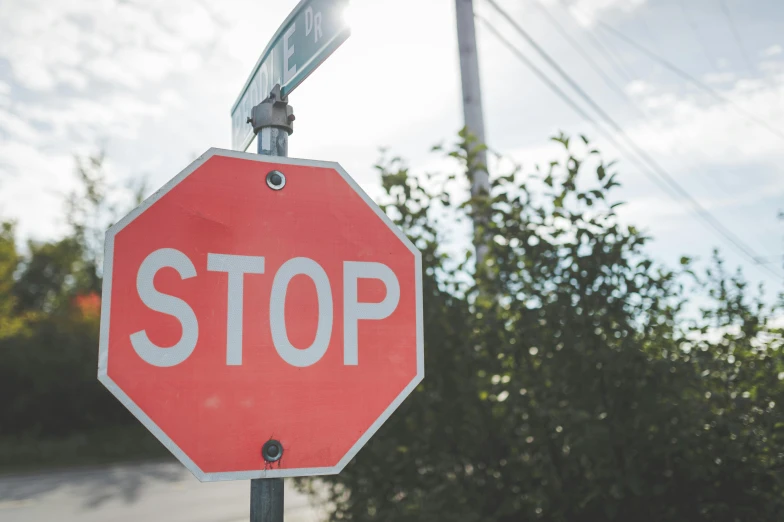 the red stop sign on the street is hanging from a pole