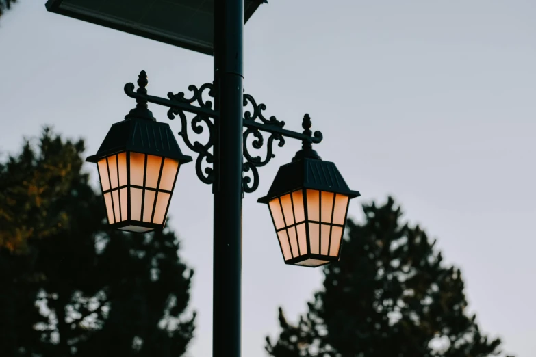 the two lights are glowing brightly on the lamp post