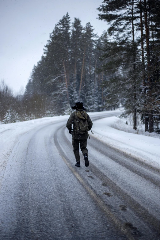 a man is running down a snowy road